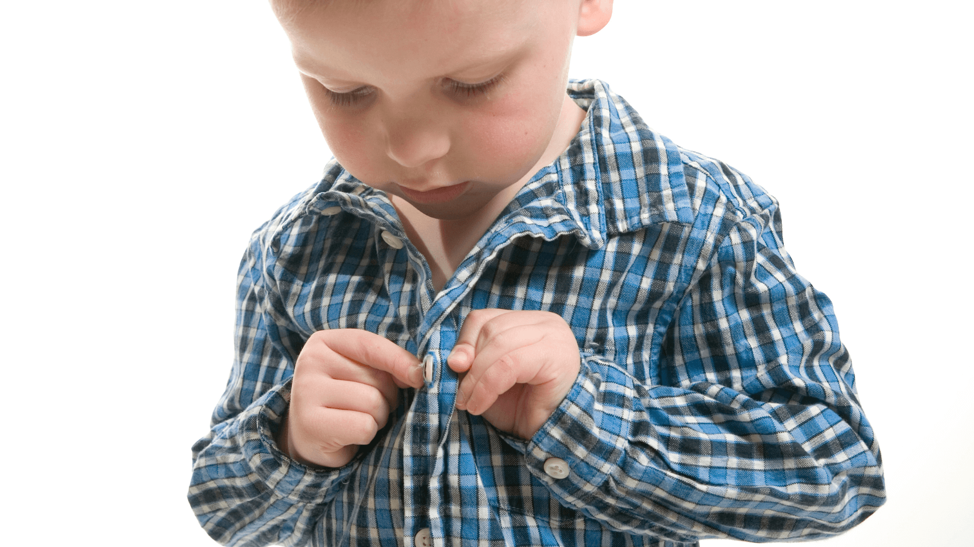 A child learning to dress himself, showcasing independence and skill development.