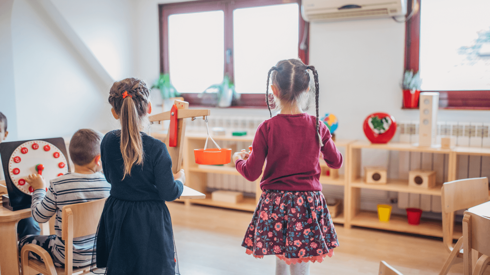 Children freely choose materials in a Montessori-prepared environment, fostering curiosity and self-directed learning.