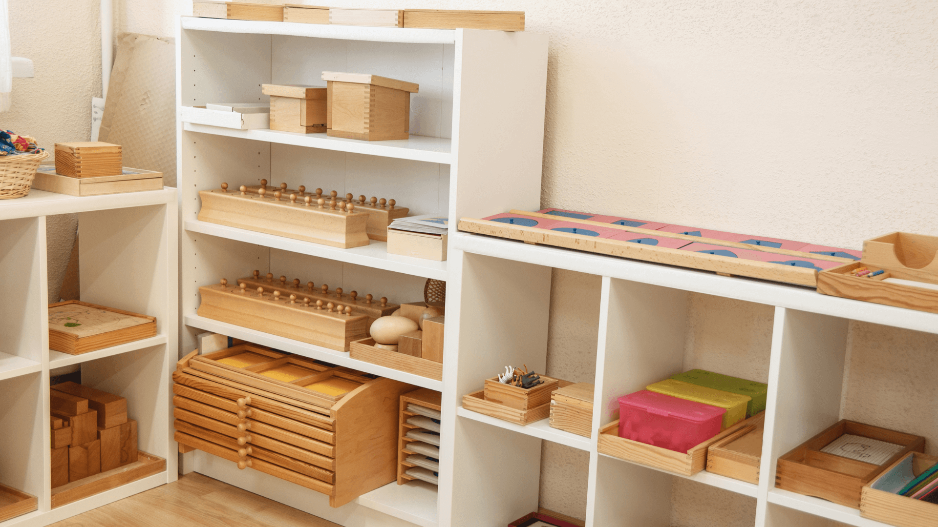A detailed view of Montessori learning materials, including knobbed cylinders, metal insets, etc., all arranged to stimulate curiosity and learning.